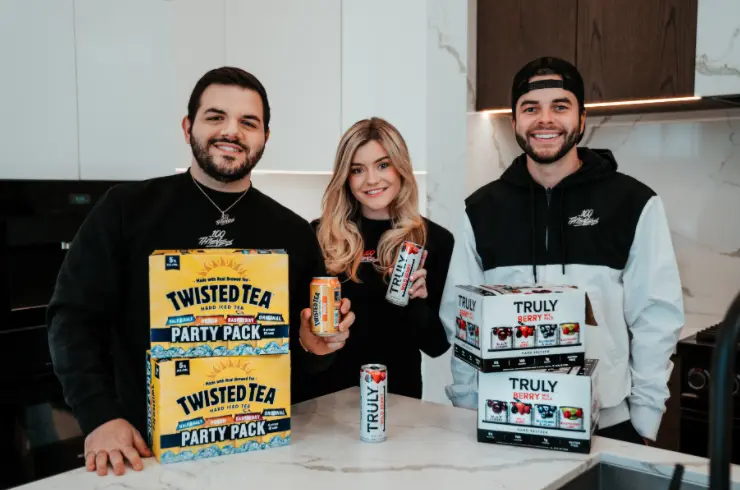 Content creators holding Twisted Tea Party Pack and Truly Hard Seltzer products for brand partnership promotion
