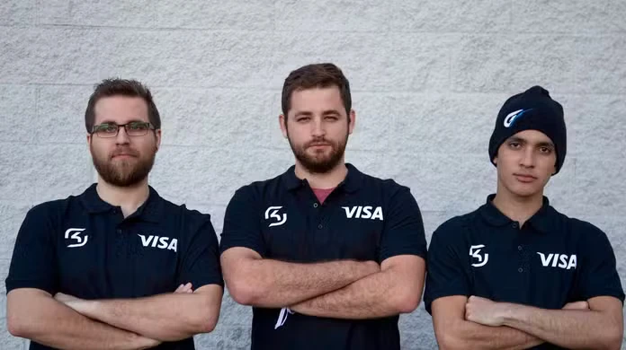 Three esports players standing with arms crossed, wearing black jerseys featuring the Visa logo, representing a financial brand partnership in esports.