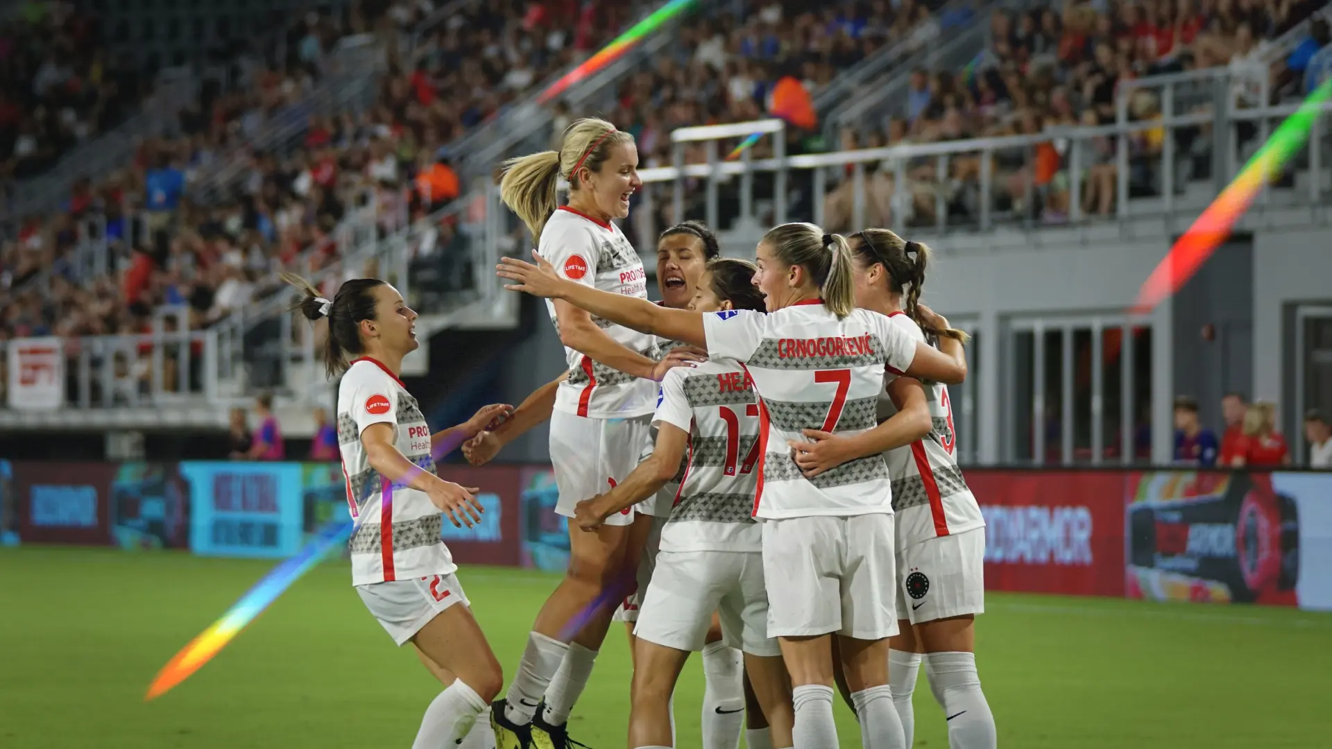 Women’s football team celebrating a goal in a packed stadium, highlighting rising audience demand and the commercial upside of women’s football sponsorship. Photo by Jeffrey F Lin on Unsplash.