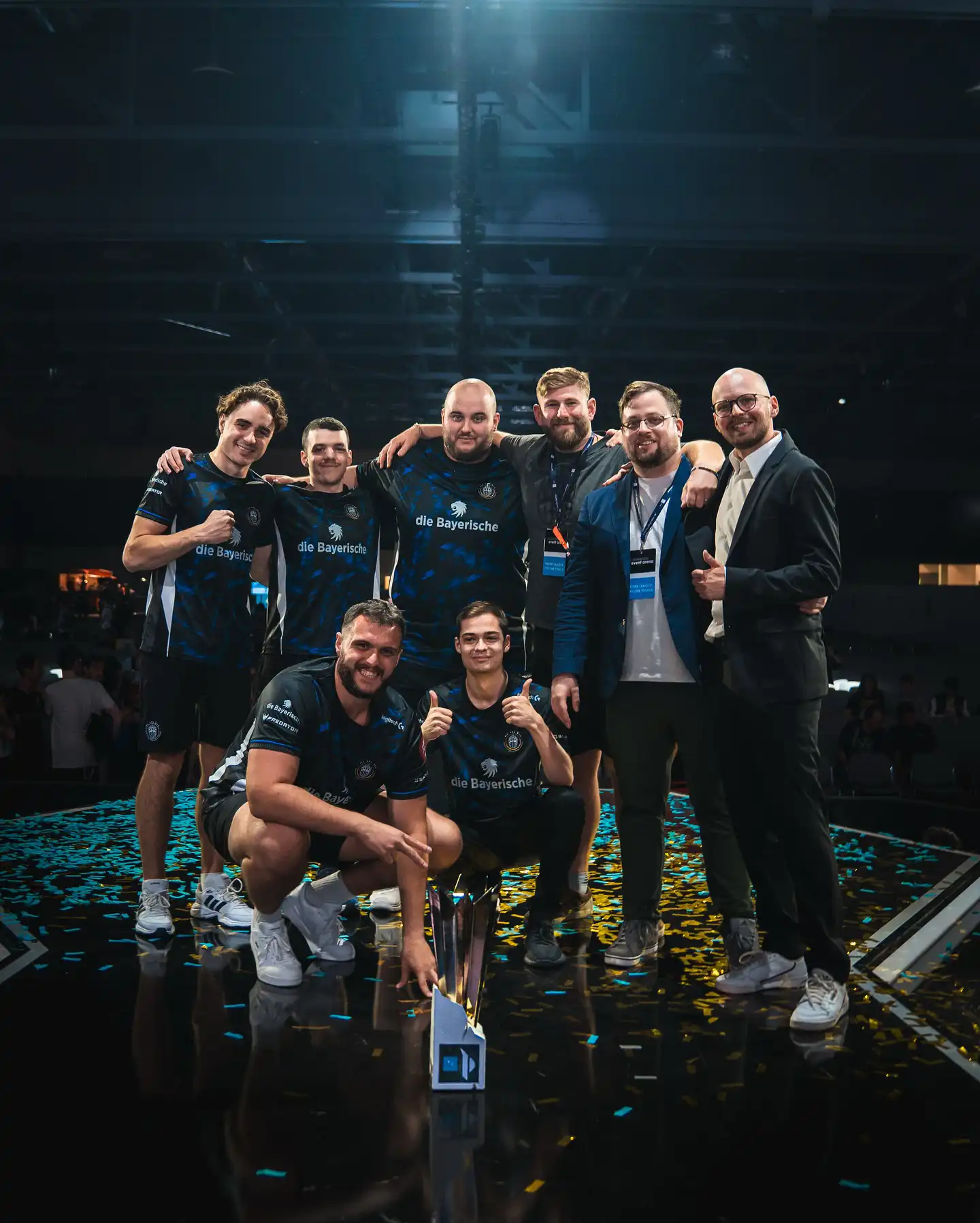 BIG esports team celebrates on stage with trophy and confetti after winning event.