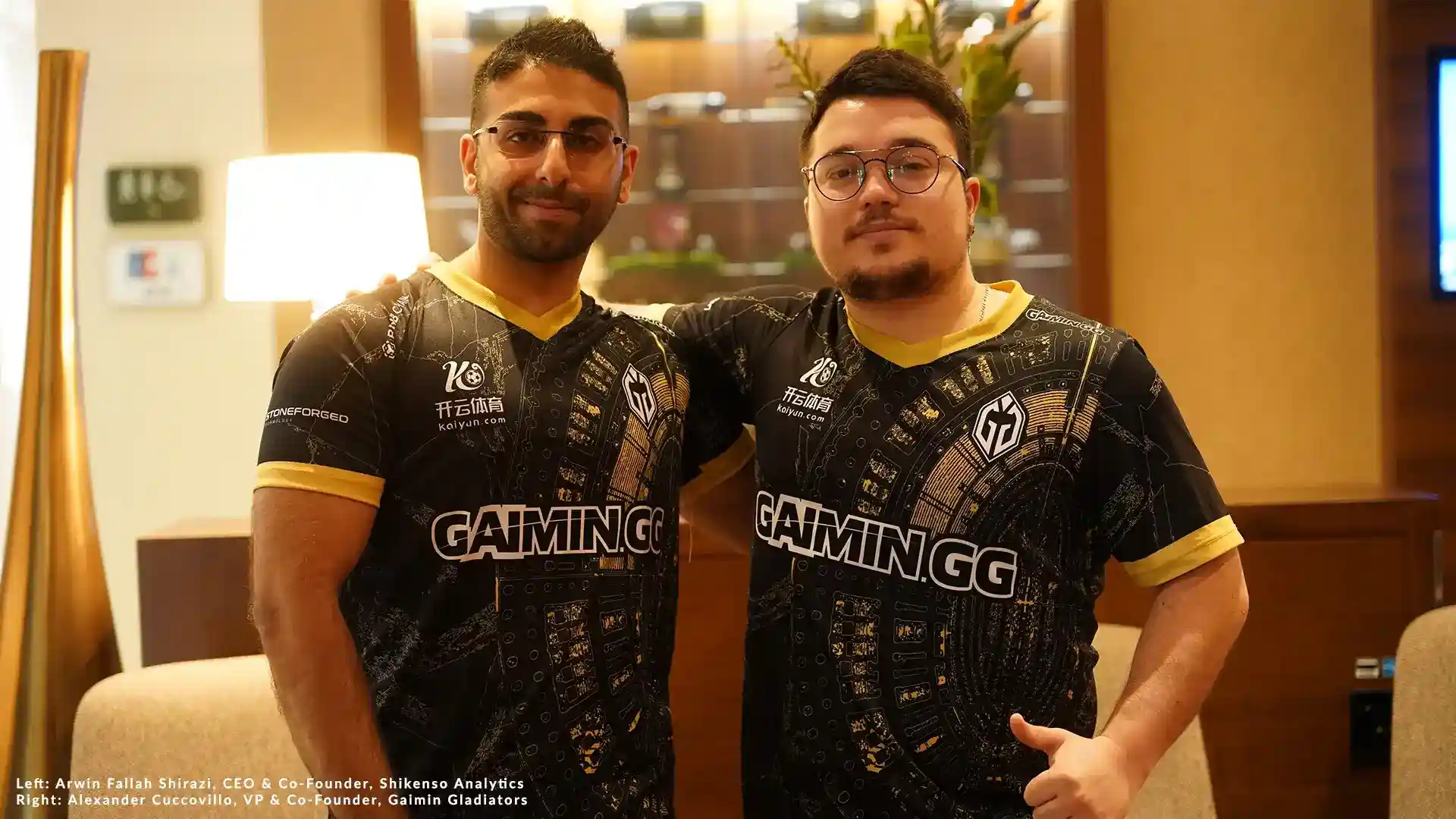 Two men wearing black and gold Gaimin Gladiators esports jerseys pose together indoors. Left: Arwin Fallah Shirazi, CEO & Co-Founder of Shikenso Analytics. Right: Alexander Cuccovillo, VP & Co-Founder of Gaimin Gladiators. The image represents the announcement of a three-year partnership between Gaimin Gladiators and Shikenso Analytics, focused on leveraging data-driven insights to optimize esports sponsorships.