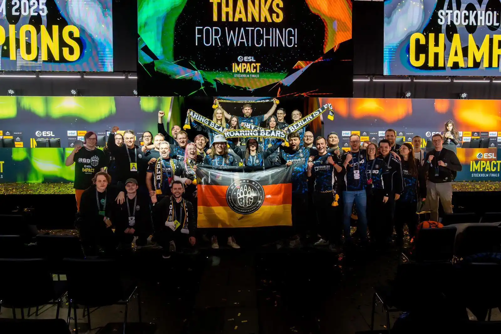 BIG fans and players celebrate ESL Impact victory on stage.