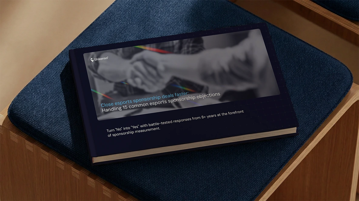 Mockup of the Shikenso guide "Close Esports Sponsorship Deals Faster: Handling 15 Common Esports Sponsorship Objections" resting on a blue cushioned seat.