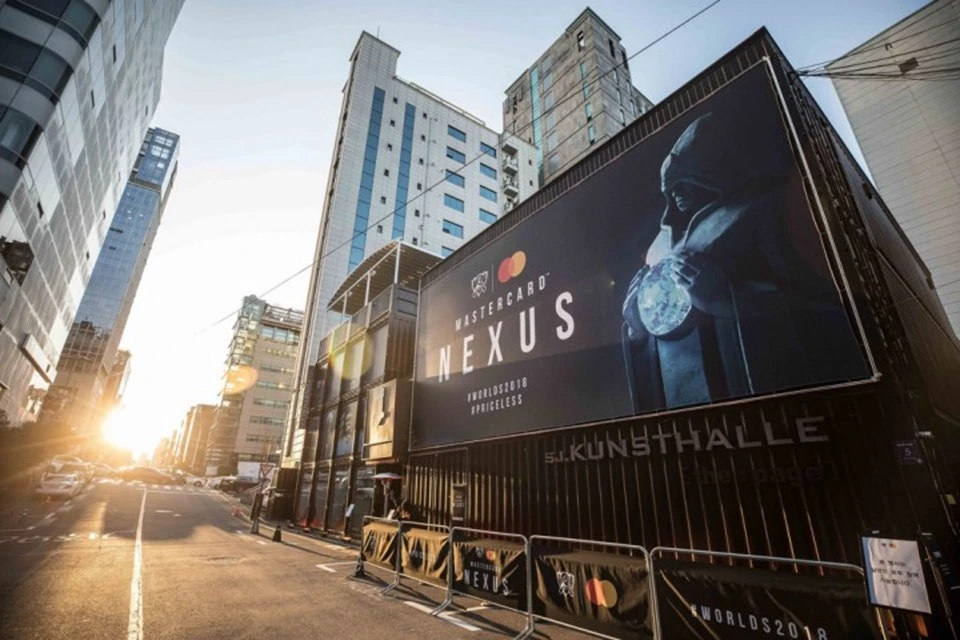 Street view of a large Mastercard Nexus installation promoting the brand’s esports sponsorship, with tall buildings and sunlight in the background.