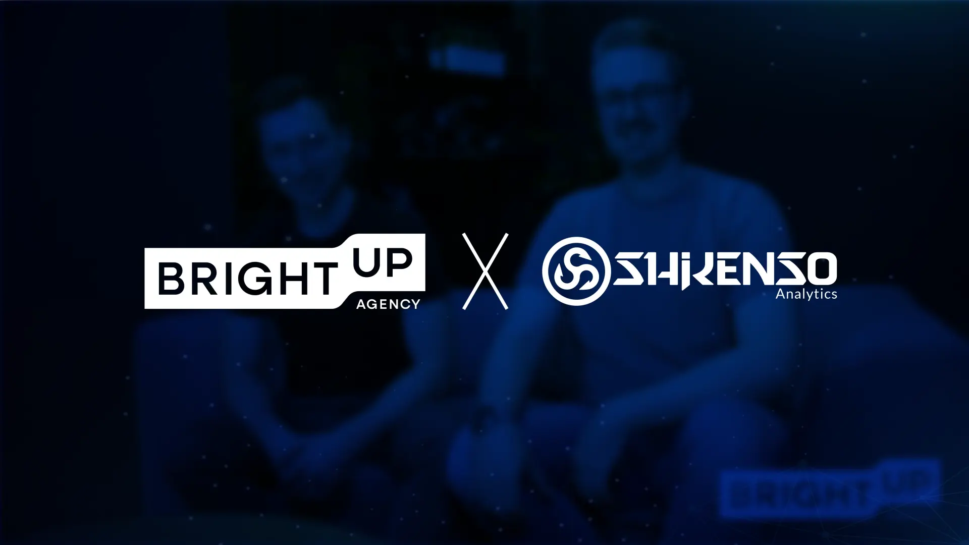 Bright Up Agency and Shikenso Analytics partnership image featuring both company logos over a dark blue background with two people sitting in the blurred backdrop.