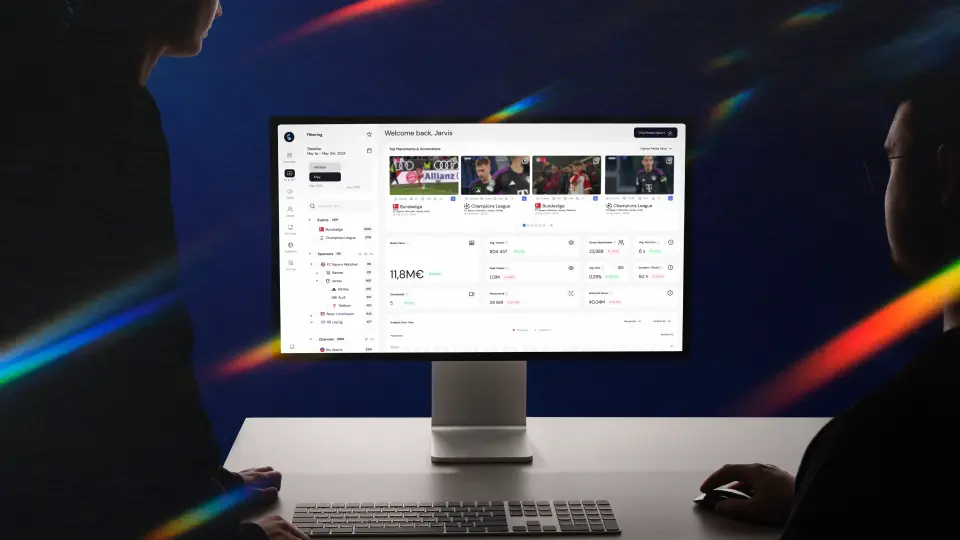 Two professionals analysing a sponsorship analytics dashboard on a desktop screen, illustrating how data insights help close more sponsorship deals.